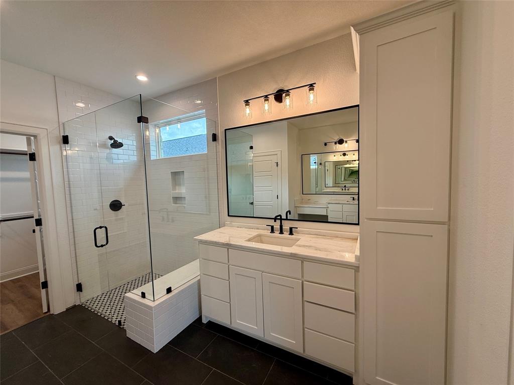 10400 T T Bury Lane Waco, TX 76708 - Photo 16 of 22 a bathroom with a double vanity sink toilet mirror and shower