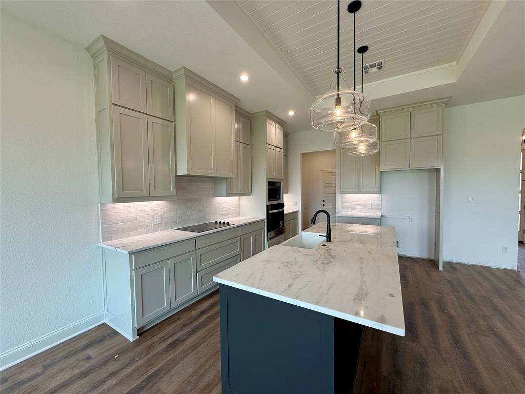 10400 T T Bury Lane Waco, TX 76708 - Photo 5 of 22 a kitchen with kitchen island a sink stainless steel appliances and wooden floor