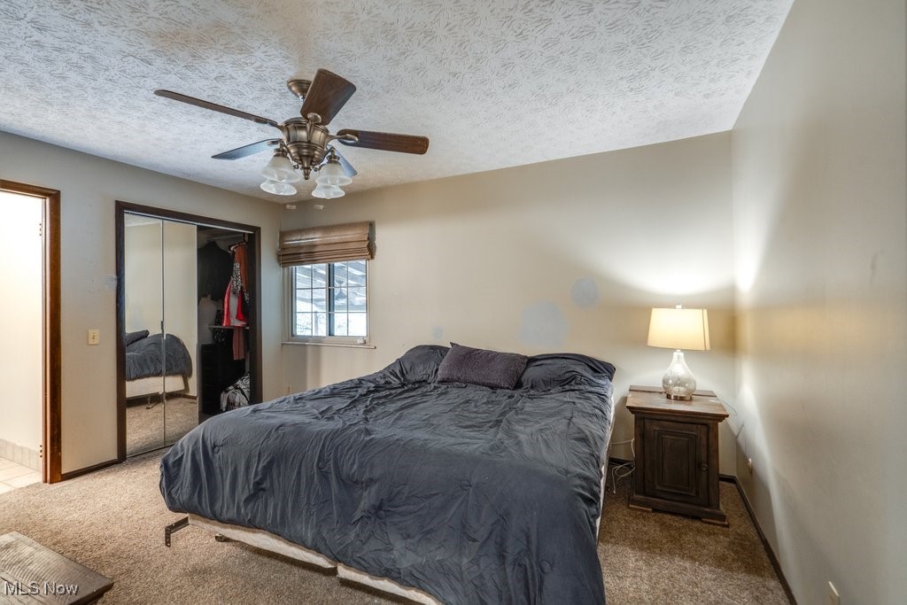 4100 Jade Road Northwest Carrollton, OH 44615 - Photo 27 of 37 Carpeted bedroom with a closet, ceiling fan, and a textured ceiling