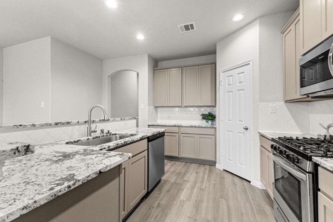 10139 Red Snapper Road Magnolia, TX 77354 - Photo 11 of 27 a kitchen with a sink stove and cabinets