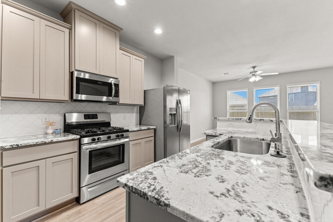 10139 Red Snapper Road Magnolia, TX 77354 - Photo 12 of 27 a kitchen with stainless steel appliances granite countertop a sink stove and refrigerator