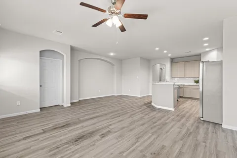 a view of an empty room with a window and wooden floor