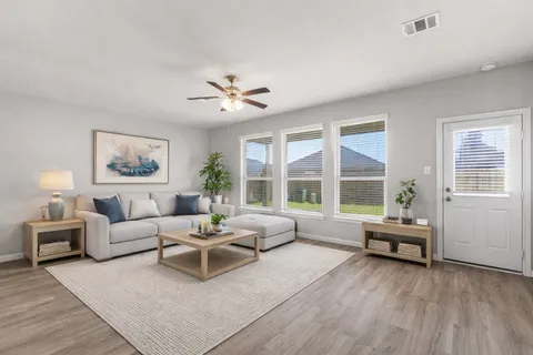 a living room with furniture and wooden floor