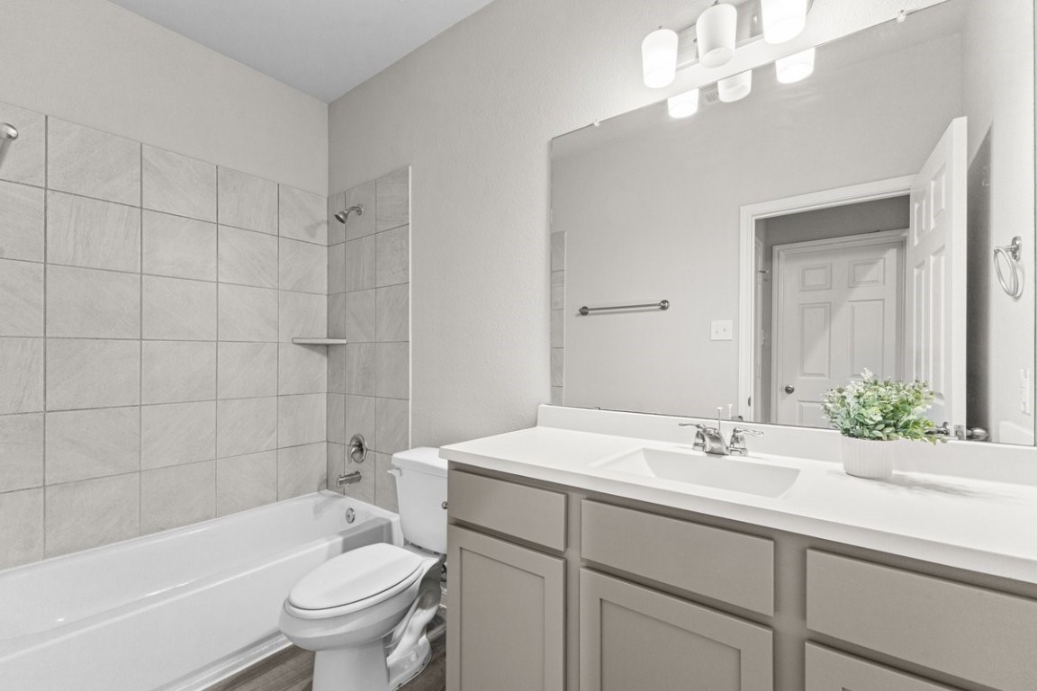 10139 Red Snapper Road Magnolia, TX 77354 - Photo 8 of 27 a bathroom with a sink a toilet a mirror a bathtub and shower