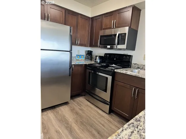 a kitchen with stainless steel appliances granite countertop a refrigerator stove and microwave