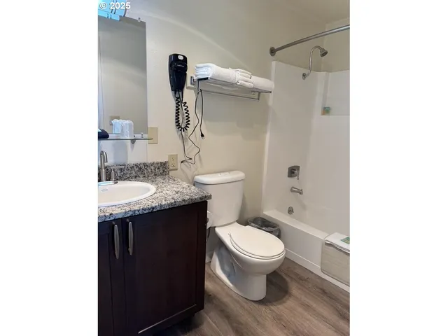 a bathroom with a granite countertop toilet sink and mirror