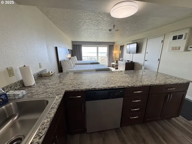 a kitchen with granite countertop a sink and white cabinets