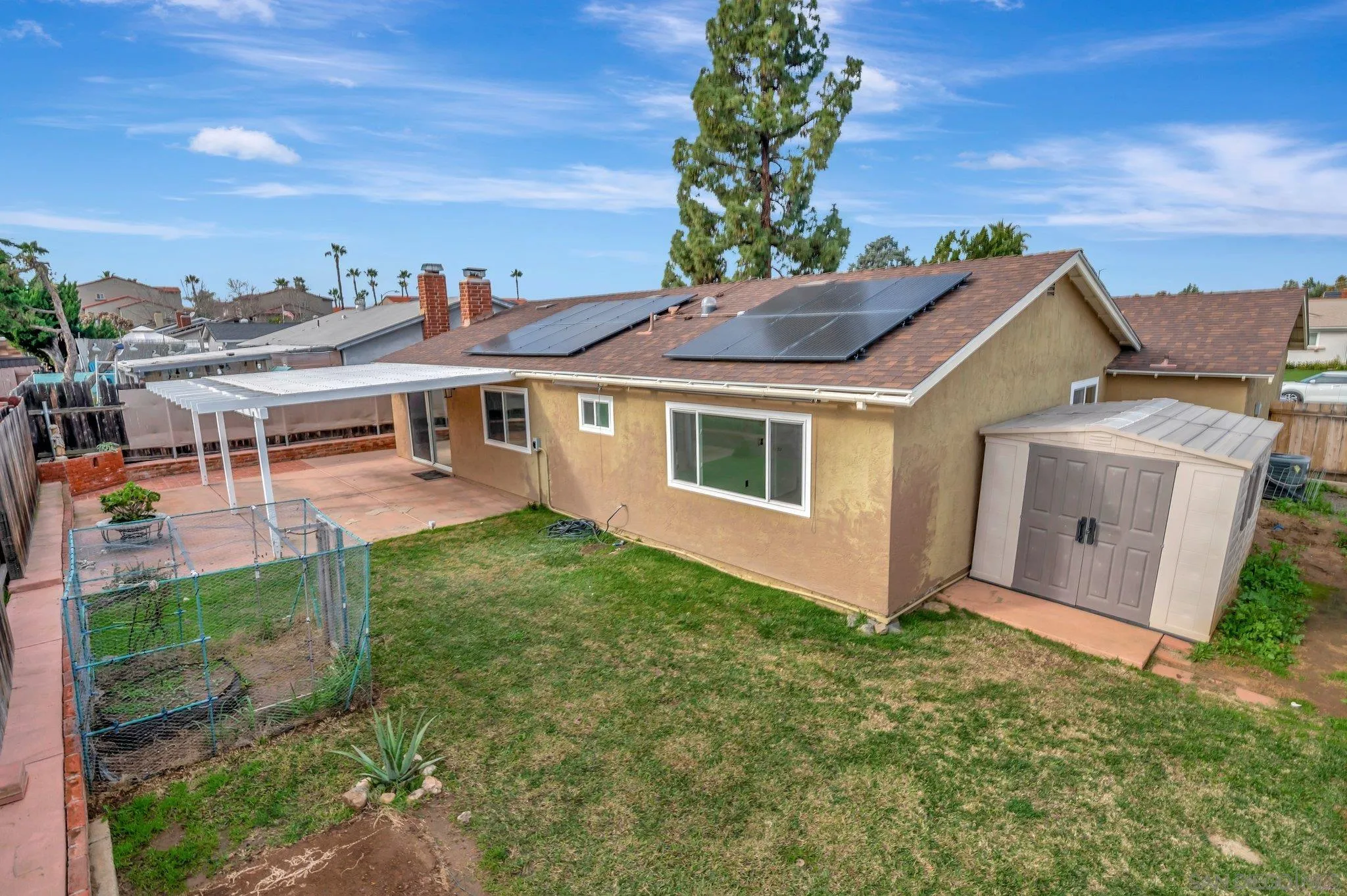9183 Via De Amor Santee, CA 92071 - Photo 28 of 32 a view of a white house with a yard and table and chairs under an umbrella
