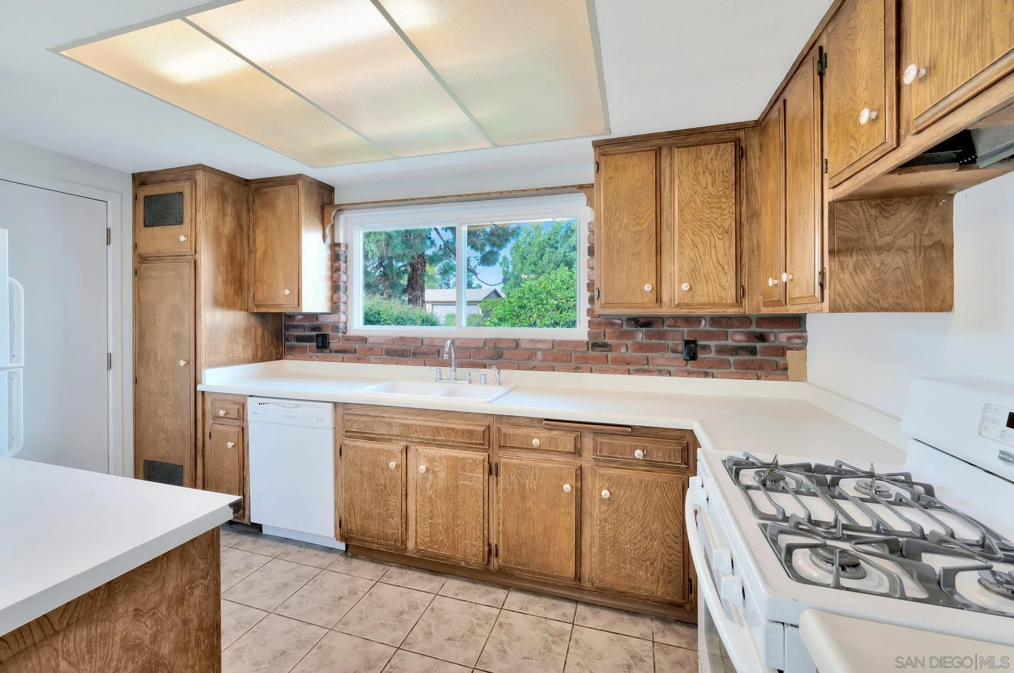 9183 Via De Amor Santee, CA 92071 - Photo 7 of 32 a kitchen with a sink stove top oven and cabinets