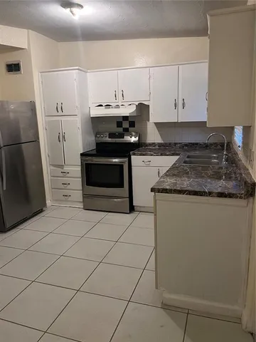 a kitchen with stainless steel appliances a stove a microwave and a refrigerator