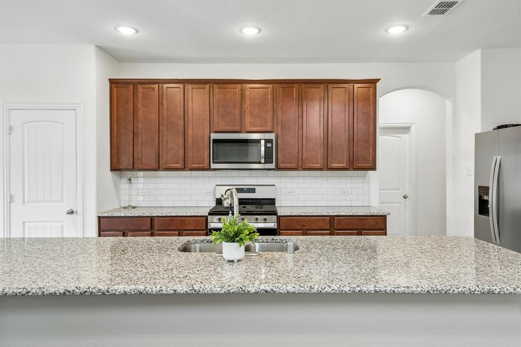 11732 Wulstone Road Fort Worth, TX 76052 - Photo 2 of 34 Expansive kitchen island with a double basin sink and a stone-finish countertop