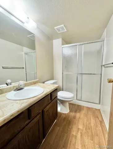 a bathroom with a granite countertop sink toilet and shower