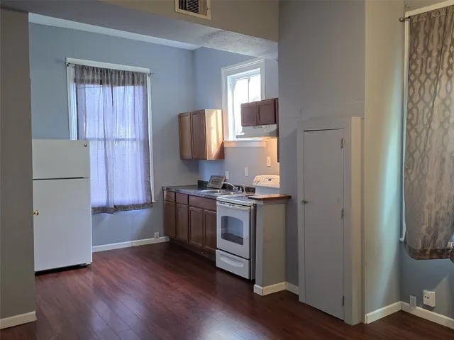 a kitchen with a refrigerator and a stove top oven