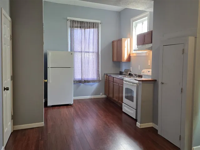 a kitchen with a white stove top oven and a refrigerator