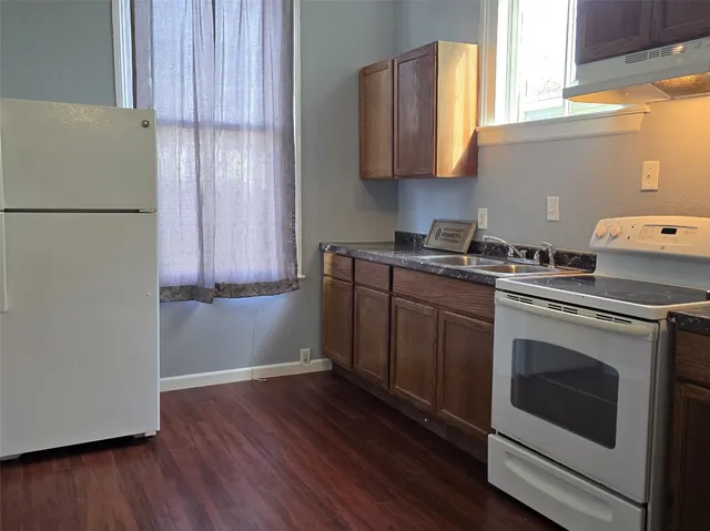 a kitchen with stainless steel appliances granite countertop a sink a stove a refrigerator and cabinets