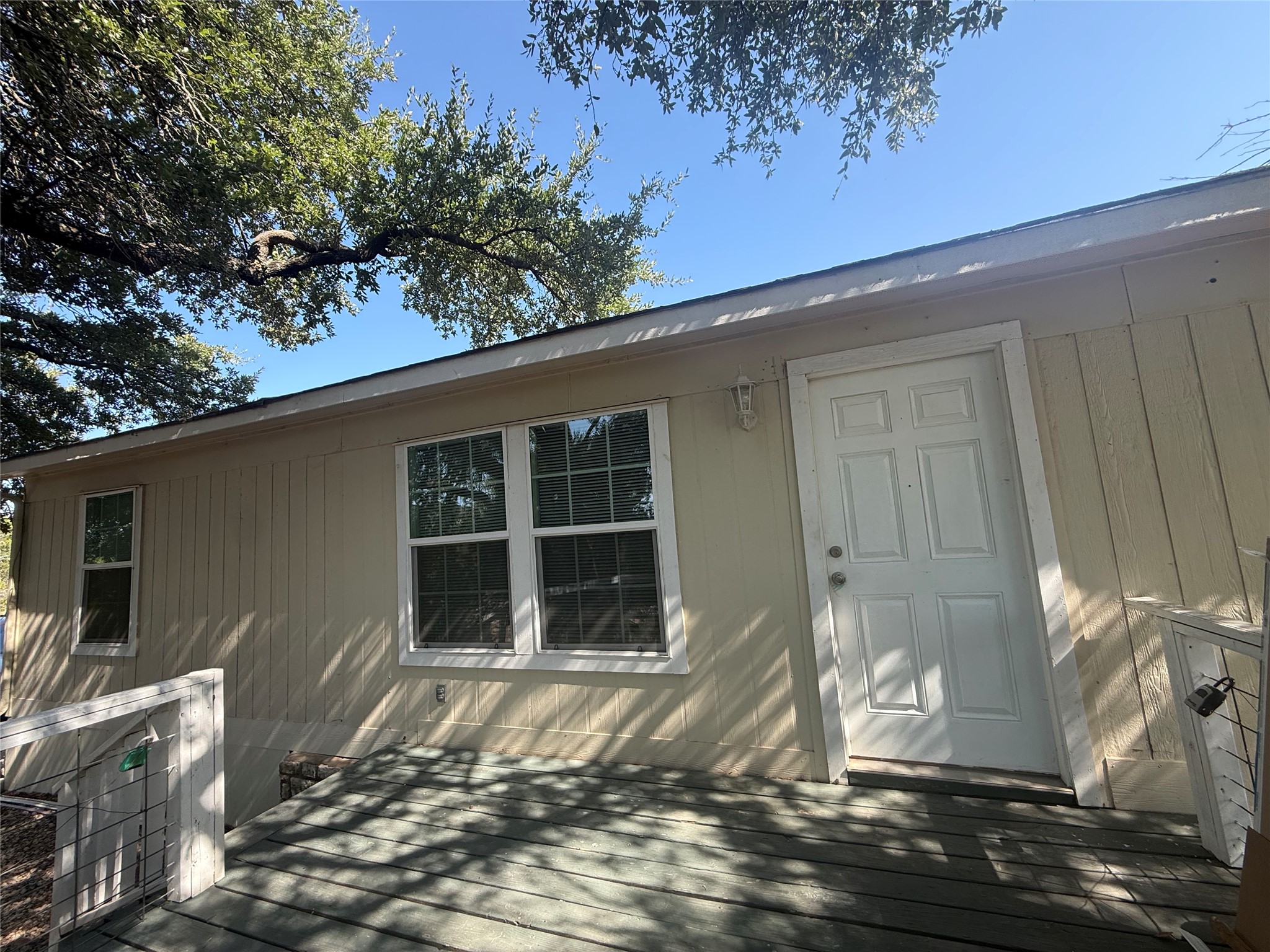 23393 Nameless Road, Unit 112 Leander, TX 78641 - Photo 1 of 16 Mature trees shade a quiet entry deck leading to the vertical siding exterior.