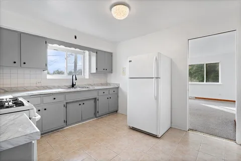 a kitchen with sink cabinets and refrigerator