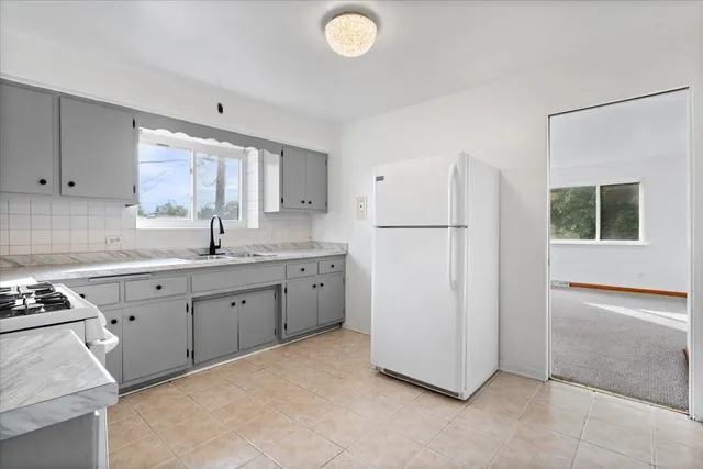 a kitchen with sink cabinets and refrigerator