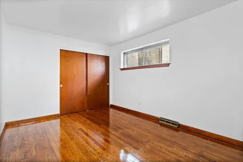 an empty room with wooden floor and closet