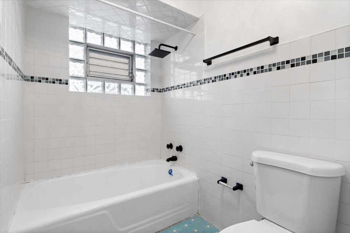 852 East 88th Place Chicago, IL 60619 - Photo 24 of 28 a bathroom with a bathtub a toilet and a shower