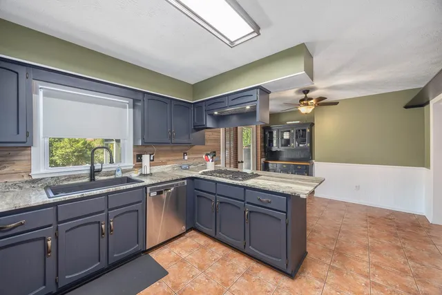a kitchen with lots of counter top space sink and wooden floor