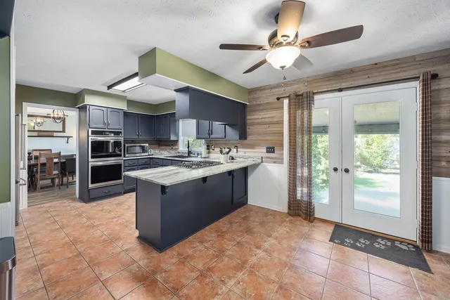 a kitchen with stainless steel appliances granite countertop a stove sink and cabinets