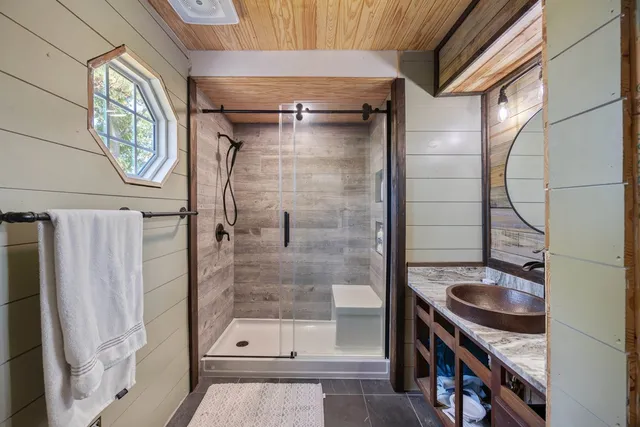 a bathroom with a shower a mirror and a sink