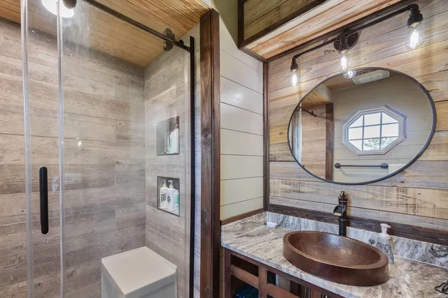 a bathroom with a sink a mirror and a shower