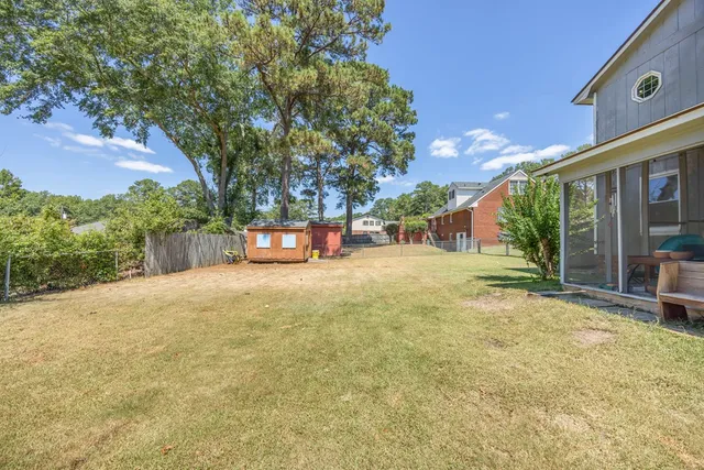 a view of a house with large tree and plants