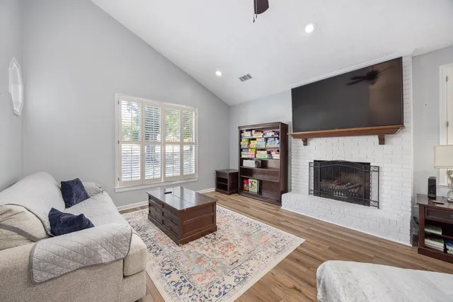 a living room with furniture a flat screen tv and a fireplace