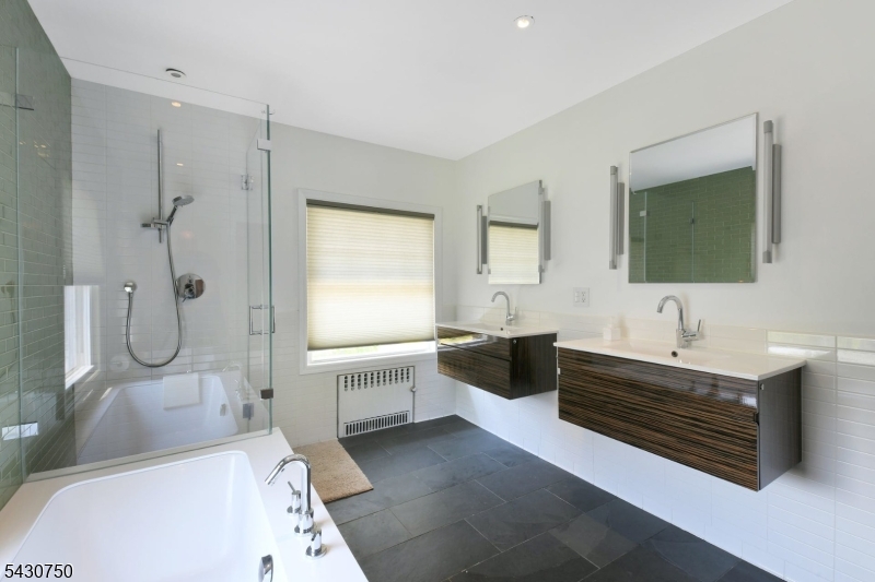 42 Norman Road Montclair, NJ 07043 - Photo 21 of 33 a bathroom with a tub sink double vanity and mirror