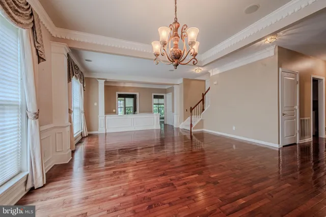 a view of a livingroom with wooden floor and stairs