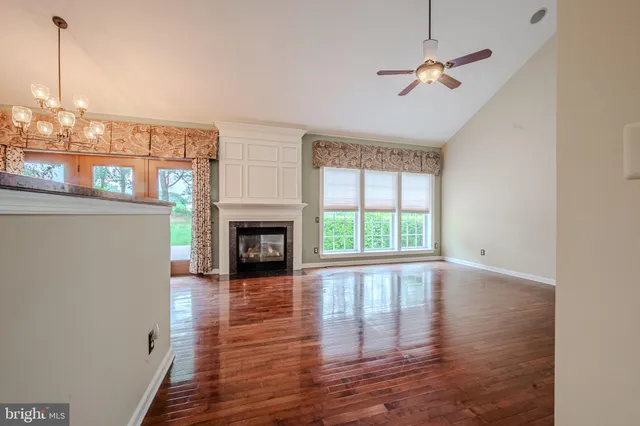 a view of empty room with wooden floor and fireplace