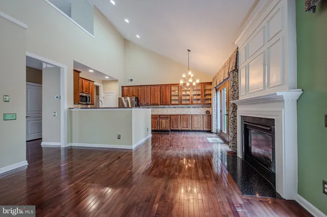 a living room with stainless steel appliances granite countertop a fireplace cabinets and a counter top space