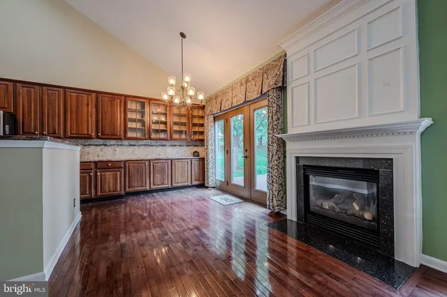a view of a big room with wooden floor fireplace and windows