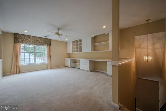 a view of an empty room with a cabinet and mirrors