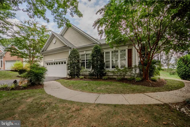 a view of a house with a yard and potted plants