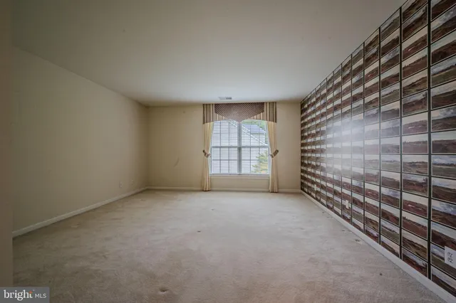 a view of an empty room with wooden floor and fireplace