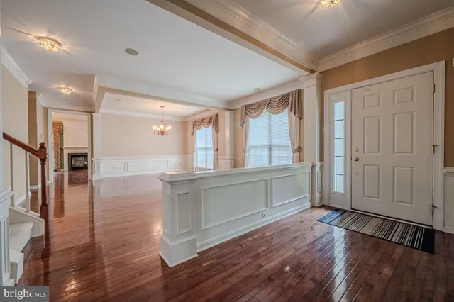 a living room with stainless steel appliances wooden floors and large window