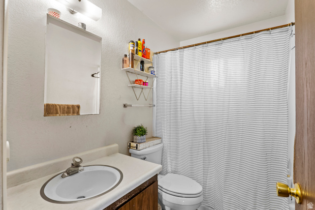 2327 880 North Provo, UT 84601 - Photo 6 of 15 Bathroom featuring a single vanity with an integrated sink, a rectangular wall-mounted mirror, and a toilet