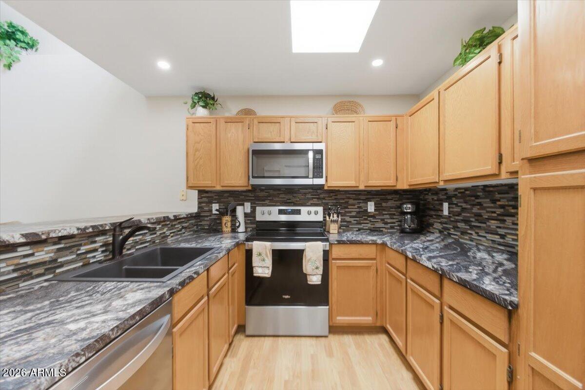 14300 West Bell Road, Unit 211 Surprise, AZ 85374 - Photo 12 of 42 a kitchen with a sink stove and microwave