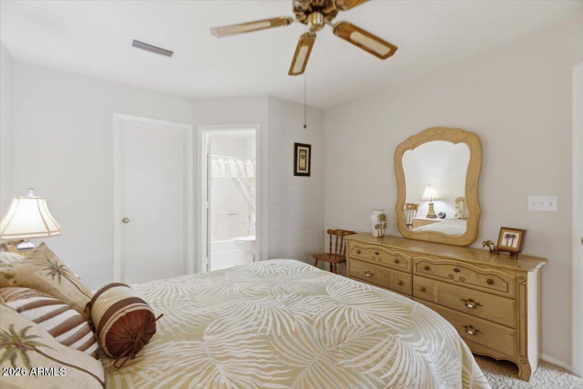 14300 West Bell Road, Unit 211 Surprise, AZ 85374 - Photo 23 of 42 a bedroom with a bed and a chandelier