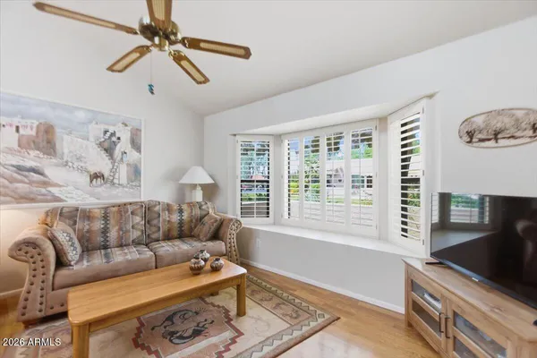 a living room with furniture kitchen view and a chandelier