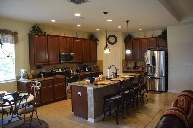 a bed sitting in a kitchen next to a cabinet