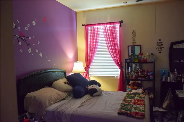 a large bed sitting in a bedroom next to a window