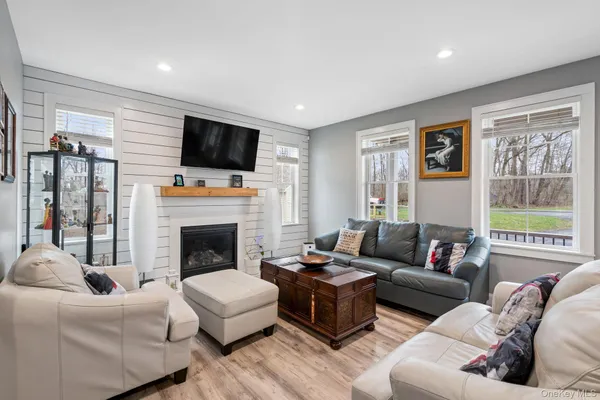 a living room with furniture a flat screen tv and a fireplace