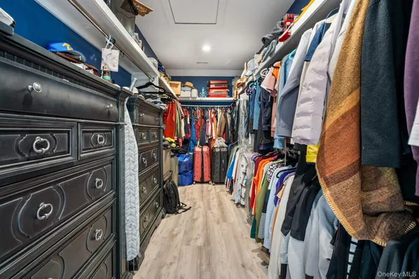a view of walk in closet with clothes and shoes