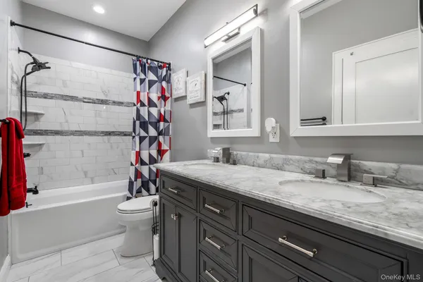 a bathroom with a granite countertop sink a toilet and bathtub