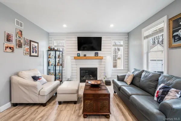 a living room with furniture a flat screen tv and a fireplace