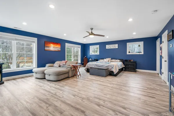 a bedroom with furniture and a large window